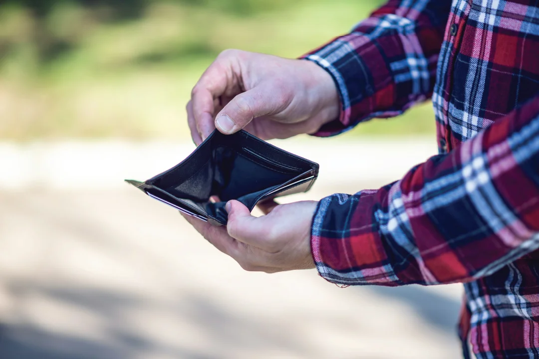 closeup of man's hands holding open an empty wallet